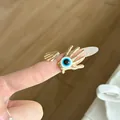 Macro view of a vintage gold hand-shaped ring featuring a blue evil eye detail. - Vintage Gold Hand Evil Eye Ring (JZ0916B)