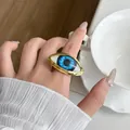 Close-up detail of a vintage exaggerated evil eye ring with blue iris on model hand - Blue Demon Eye Ring Jz0892b