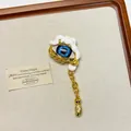 Close-up detail of vintage evil eye jewelry with blue pupil and dripping white enamel. - Blue Demon Eye Brooch Xz0163c