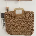 Detailansicht einer handgefertigten Strohtasche mit quadratischem Holzgriff. - Hellbraun