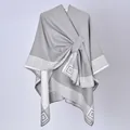 Dettaglio dello scialle poncho grigio da donna con bordi a meandro e chiusura laterale - 130x150cm / Bordo a Greca Grigio con Cinturini