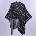 Vista dettagliata della mantella poncho grigia a quadri con elegante nodo laterale e spacco. - 130x150cm / Quadri con Barre Nero e Grigio