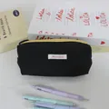 Close-up of minimalist black ins style pencil case with colorful pens in foreground - 19x6x7cm / Black