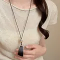 Collana lunga elegante in stile cinese con ciondolo a trapezio nero su maglia beige - Collana a triangolo irregolare marrone