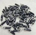 Close-up of bulk black marble hexagonal pillar bullet pendants with silver clasps. - Black Line Turquoise