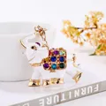 Detailed close-up of a white elephant keychain decorated with colorful rhinestones - White
