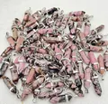 Macro view of multiple natural pink rhodonite crystal bullet pendants with silver bails - Rhodochrosite