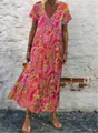 Detailansicht einer Frau in einem lebhaften rosa Maxikleid mit V-Ausschnitt - S / Rosa-Orange Paisley (VINT-8865-2)