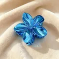 Elegant blue metallic Plumeria flower hair claw clip on soft beige velvet texture - 8cm Plated Cyan Blue