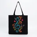Close-up of black canvas tote bag with colorful musical note and butterfly embroidery. - Blue Treble Clef Notes Butterfly Style (hm7349)