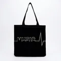 Detailed view of the black canvas tote bag featuring a white music heartbeat print - MUSIC EKG White Print Black Style (hm7354)