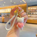 Adorable white knitted teddy bear keychain holding a pink heart with white braided strap - Heart Hug Bear / White