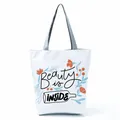 Close-up of white tote bag featuring floral illustration and Beauty is INSIDE slogan - Bottle Floral Aesthetic (hl5286)