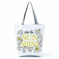 Detailed view of a white canvas tote bag featuring floral Be the Sun Shine print design - Yellow Inspirational Letter Floral (hl5297)