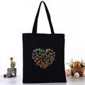 Black canvas tote bag featuring a vibrant butterfly heart tree print for daily use - Butterfly Heart Tree Style (L4228-9) / Black