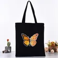 Black canvas tote bag featuring vibrant butterfly series print for fashionable daily use - Gradient Artistic Letter Butterfly Style (L4228-10) / Black
