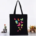 Stylish black canvas tote bag featuring a colorful butterfly print in a cozy setting - Vibrant Colorful Butterfly Set Style (L4228-20) / Black
