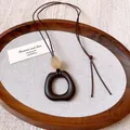 Close-up of irregular dark brown oval pendant necklace with minimalist wax cord - Square (HN9973)
