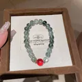 Primer plano de pulsera de cuentas de cuarzo verde con ágata roja y detalles dorados - Pulsera 56# (Con Caja de Regalo) / Fantasma Verde Cuarzo Fresa