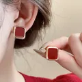 Close-up of elegant red enamel square stud earrings with gold-tone borders on a model - Red Square Enamel (Silver Earring Post 3#)