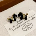 Detailed view of elegant black flocked horse stud earrings with gold accents in a gift box - Horse Shape (HE29869) / Black