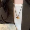 Dettaglio della collana con ciondolo in occhio di tigre placcato oro e corda - Stile Tondo (1#)