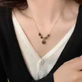 Dettaglio della collana vintage in pietra occhio di tigre indossata su catena dorata - Stile Tondo (4#)