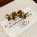Close-up of retro flocking horse stud earrings with gold metallic details - Horse Shape (HE29869) / Brown
