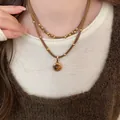 Elegante collana in cordino marrone placcato oro con ciondolo occhio di tigre indossata. - Stile Stratificato (23#)