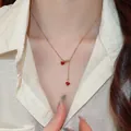 Élégant collier plaqué or avec deux petits pendentifs en forme de cœur rouge sur mannequin. - Collier en Y / Or-Rouge