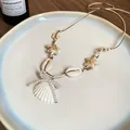 Detailansicht einer Halskette mit Muscheln, Seesternen und einer Perlen-Schleife. - Perlenbogen Muschel Stil