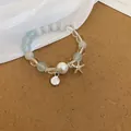 Elegante pulsera de cuentas de cristal azul y blanco con dijes de mar y estrella - Pulsera 35# (Colgante de Concha y Estrella de Mar) / Plateado - Piedra Ojo de Gato Azul
