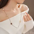 Collana lunga placcata oro con occhio di tigre e perle indossata su maglione bianco - Stile Perla Artificiale 10mm (26#)