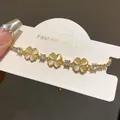 Close-up of elegant gold flower bracelet with sparkling zircons and opal-like stones - 1# Bracelet
