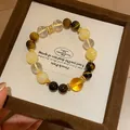 Macro view of a natural tiger eye and clear quartz stone beaded bracelet in a gift box - Style 21 (Multi-Stone) / Coffee-Clear