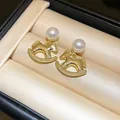 Macro view of 18k gold-plated rocking horse earrings with pearls in a jewelry box - Pearl Hammered Horse (37#)
