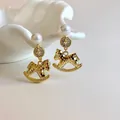 Detailed macro view of gold rocking horse earrings with elegant pearls and pavé stones - Pearl Horse (2#)