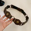 Vintage brown leather belt with geometric cutout oval studs and gold circular metal rings - Coffee