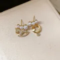 Elegant asymmetric gold earrings featuring a zircon rocking horse and pearls on beige texture - Gold Asymmetric Horse (37#) / 925 Silver Needle / Gold White