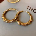 Detail view of bold leopard print bamboo texture hoop earrings with gold-tone hardware - Round Bamboo Hoop / Gold Leopard Print