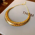 Close-up detail of a bold leopard print U-shaped collar necklace on a grey textured gift box - U-Shaped Choker / Gold Leopard Orange