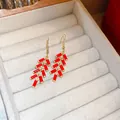 Elegant red firecracker drop earrings with golden finish displayed in jewelry tray - Vintage Firecracker Shape Style (76#) / Red