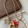 Retro wax cord necklace featuring a gold horse pendant and vibrant red beaded tassel detail. - Matte Gold
