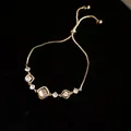 Elegant gold-tone adjustable bolo bracelet featuring square and round zircon stone charms - Cat's Eye Flower Style (HB5092) / Gold