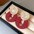 Close-up detail of retro acrylic earrings with red oval and cream marbled disc. - Geometric Splicing Style (HE21934) / Red
