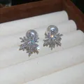 Primer plano de pendientes de copo de nieve brillantes con perlas blancas elegantes - Estilo Perla Copo Circonia 34