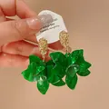 Close-up detail of stylish green resin flower earrings featuring gold textured stud design - Silver Earring Post-Green