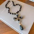 Detailed close-up of a vintage flower pendant necklace with elegant marbled resin - Necklace / Gold-Black