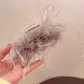 Close-up detail of a fluffy grey ostrich feather hair claw clip for elegant bun styling - Khaki Feather Style