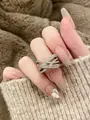 Detailed close-up view of a silver crisscross ring with sparkling cubic zirconia stones - Cross Open Style (HR1368) / Silver